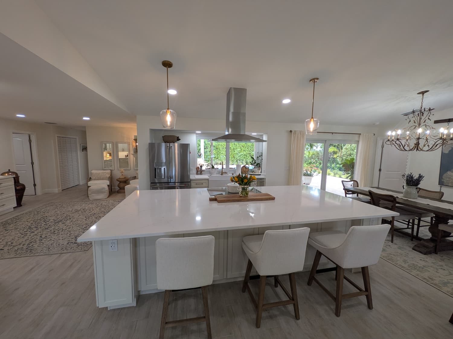 Open-concept luxury kitchen with large white quartz island and pendant lighting